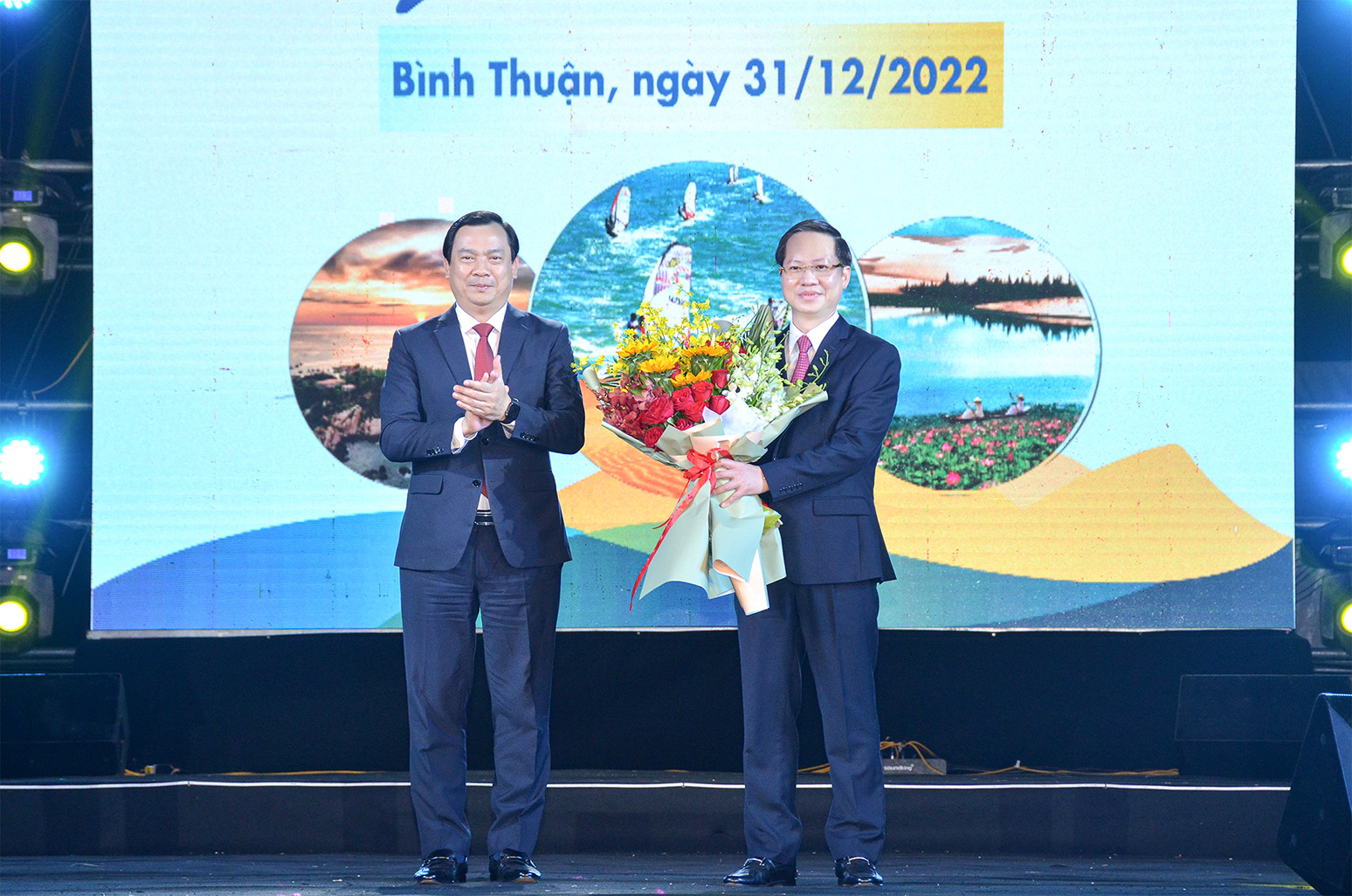 Tổng cục trưởng Tổng cục Du lịch Nguyễn Trùng Khánh trao hoa chúc mừng đơn vị đăng cai Năm Du lịch quốc gia cho Chủ tịch UBND tỉnh Bình Thuận Đoàn Anh Dũng.